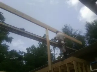 Carpenter setting a ridge beam over a new addition frame — Ice Dam Removal by Roofing Brothers in Nineveh